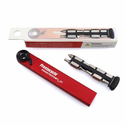 A compact red Prestacycle PocketRatchet Lite pocket multi-tool is shown next to its packaging, displaying the tool with several bits neatly stored in its handle.