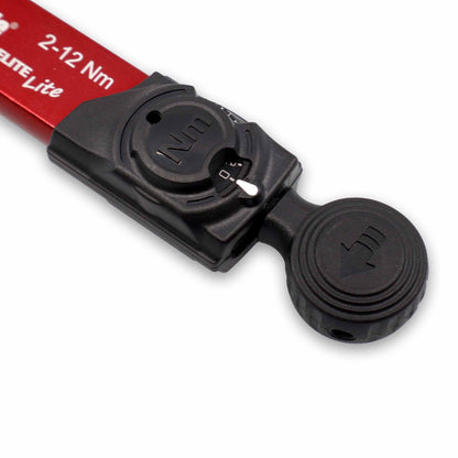 Close-up of the Prestacycle TorqRatchet ELITE Lite showing its black and red ratchet head with a circular adjustment dial, white indicator, and arrow symbol on the textured knob. Labeled 2~12Nm, this is a portable torque multi-tool ratchet.